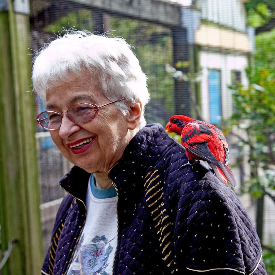 Mom with red tropical bird on her shoulder