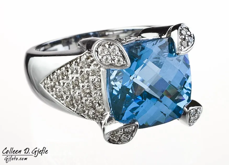 Diamond ring featuring a large multi faceted blue topaz gemstone