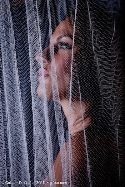 Young woman behind gauze curtain